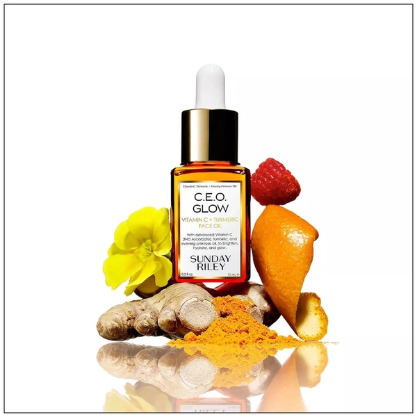 This creative showcases a premium face oil surrounded by its raw botanical sources like turmeric, ginger, and citrus peel against a bright white background.